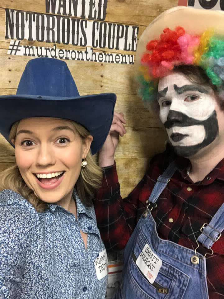 A cowgirl and a rodeo clown in front of a marquee
